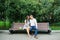 A guy and a girl, a couple in love, sit on a bench in the Park in the summer and have fun. Valentine`s day