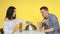 A guy and a girl on a date eat fast food and drink drinks from glasses on a yellow background. Date. The concept of