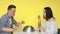 A guy and a girl on a date eat fast food and drink drinks from glasses on a yellow background. Date. The concept of