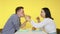 A guy and a girl on a date eat fast food and drink drinks from glasses on a yellow background. Date. The concept of