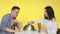 A guy and a girl on a date eat fast food and drink drinks from glasses on a yellow background. Date. The concept of