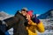 Guy and girl embrace and smile on the background of snow-capped mountains and blue sky. Happy young couple taking selfie