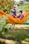 Guy and girl in hammock in nature toast with beer with female fr