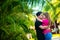 Guy and girl kissing near tropical plants