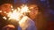 A guy and a girl light sparklers in the winter forest for Christmas.