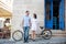 Guy and girl near tandem bike, walls and vintage door