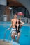 Guy and girl posing against the swimming pool with perfect aqua water and taking selfie photo with monopod on the resort