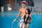 Guy and girl posing against the swimming pool with perfect aqua water and taking selfie photo with monopod on the resort