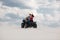 The guy and the girl ride a quad bike in the desert, having fun and enjoying, a couple of lovers