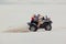 The guy and the girl ride a quad bike in the desert, having fun and enjoying, a couple of lovers