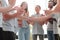 Guy and girl shaking hands sitting in a circle of friends.