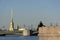 guy with the girl sitting on the embankment, opposite the Peter-Paul fortress, bridge, Neva river, Sunny day