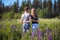 A guy and a girl are walking in the field of lupines