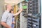 The guy and the girl work in the server room. Experts switch the wires in the racks of the datacenter. Man and woman repair