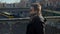 guy with glasses moves along bridge city, against background pedestrian bridge.