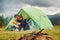 Guy with his girlfriend sits near tent. Majestic Carpathian Mountains. Beautiful landscape of untouched nature