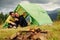 Guy with his girlfriend sits near tent. Majestic Carpathian Mountains. Beautiful landscape of untouched nature