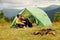 Guy with his girlfriend sits near tent. Majestic Carpathian Mountains. Beautiful landscape of untouched nature