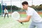 Guy hitting two handed backhand during paddle tennis match