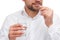 A guy is holding a glass of water and is about to drink a capsule in his hand close-up on a white isolated background