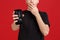 A guy holds a broken modern mobile phone and covers his mouth with a hand from fright.