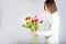 Guy holds flowers. Tulips in the hands of a young man. Flower congratulations for women.Male hands with bouquet of spring flowers