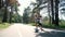 Guy holds girl`s hand when she rides a skateboard