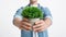 Guy holds plant in eco pot in hands