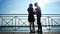 Guy hugging and kissing his girlfriend in sunbeam, sweet couple standing on quay of lake