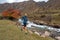 A guy jogs across a mountain river