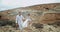 Guy and lady walking through the rocks in amazing landscape view they wearing beautiful dress code enjoying the moment