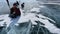 A guy launches a drone sitting on the ice of frozen Lake Baikal near Olkhon Island.