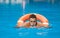 A guy in a life buoy in a pool learns to swim