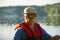 A guy in a life jacket holds a paddle in his hands while sleeping on a canoe