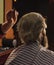 Guy with long dyed blond hair close up. Do not cut your own hair. Barber works on hairstyle for bearded man barbershop