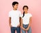 Guy looking at girl, posing together on pink background