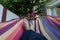 Guy lying down in a colorful Hammock resting barefoot.Crossed legs of a man taking nap in blue hippie pants in a summer garden of