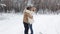 A guy makes a surprise gift to a girl in a snowy winter forest. A happy girl and a guy embrace and spin in the middle of