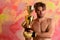 Guy with naked torso in golden boxing gloves holds prize.