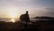 Guy opens his arms wide against beautiful gold sunset on beach, expresses sense of freedom, happines