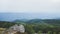 Guy at the peak of a mountain having a beautiful view of the distant hills