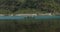 A guy photographs a girl, sitting in a rowing boat in the mountain lake