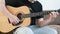 Guy playing an acoustic six-string guitar. learning to play a musical instrument close-up.