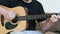 Guy playing an acoustic six-string guitar. learning to play a musical instrument close-up.