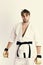 Guy poses in white kimono wearing golden boxing gloves