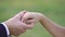 Guy putting beautiful ring on finger of his bride and kisses her hand. Close up