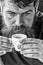 Guy relaxing with espresso coffee. Coffee break concept. Hipster drinking coffee close up. Caffeine recharge. Man with