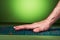 The guy `s hand lies on a green massage mat in twisted form on a green background. Advertising and subject shooting. For