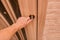 Guy`s hand opens or closes a wooden door with glass trims