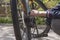 The guy`s hands adjust the chain on the bike. Bicycle wheels, rear view. selective focus